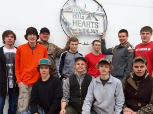 Students holding metal sign